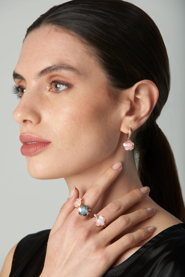 Earrings and rings in 18k rose gold with pink quartz and blue gemstones and diamonds on model in black dress