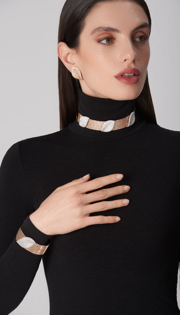 Ear cuff and bracelet in 18k white and rose gold with diamonds on model in black turtleneck