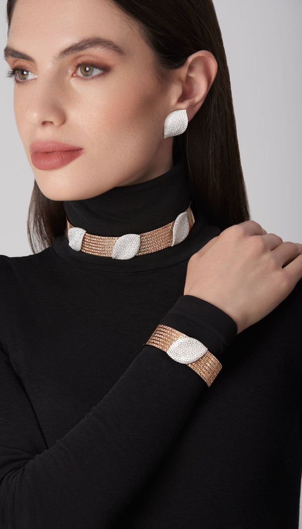 Earrings, choker, and bracelet in 18k white and rose gold with diamonds on model in black turtleneck