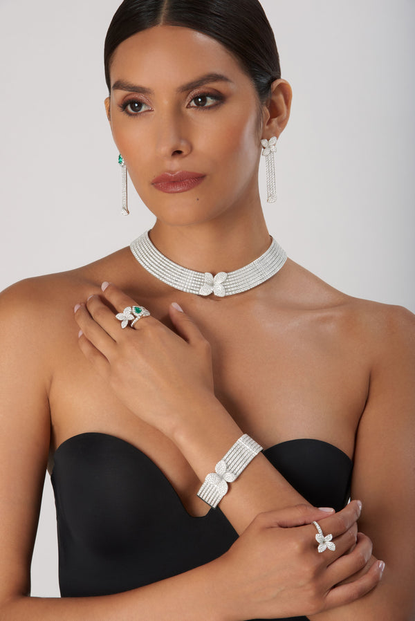 Choker, earrings, bracelet, and ring in 18k white gold with diamonds on model in black dress