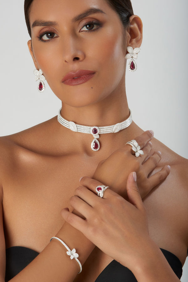 Choker, earrings, and rings in 18k white gold with rubies and diamonds worn by model in strapless dress