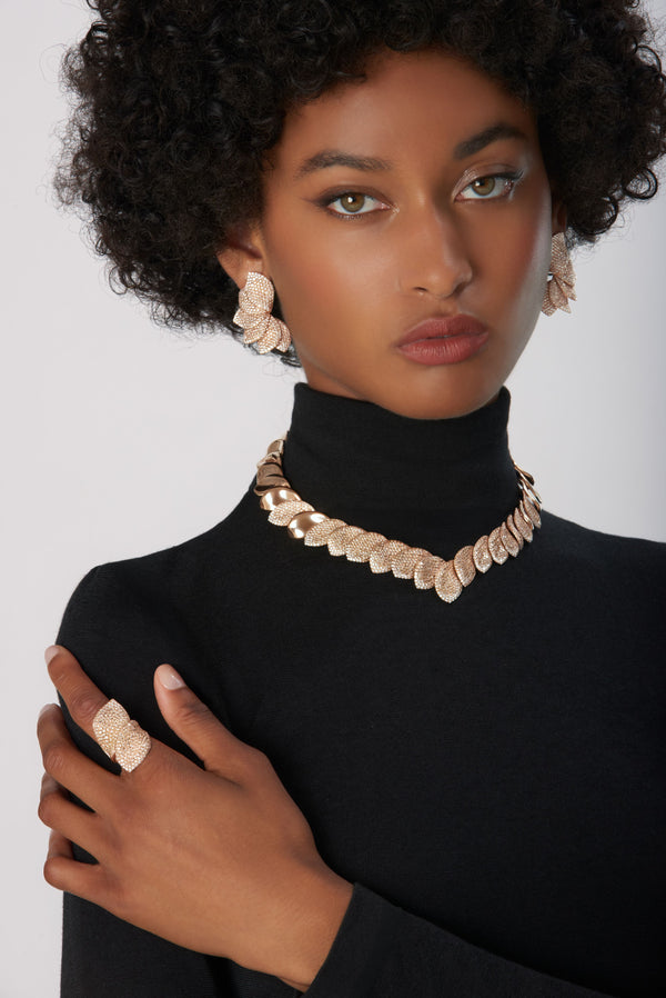 Ring, earrings and necklace in 18k Rose Gold with White and Champagne Diamonds on model wearing a black turtleneck