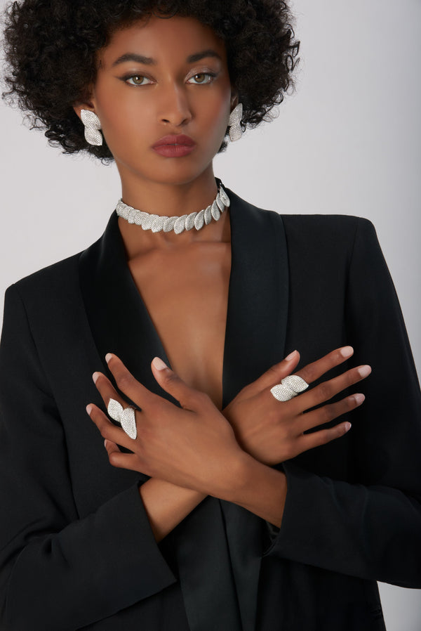 Leaf-shaped choker, earrings, and rings in 18k white gold with white diamonds on model
