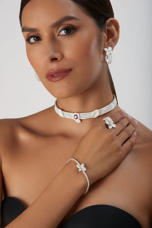 Choker, earrings, ring and bracelet with diamonds and ruby in 18k white gold worn by model in strapeless black dress