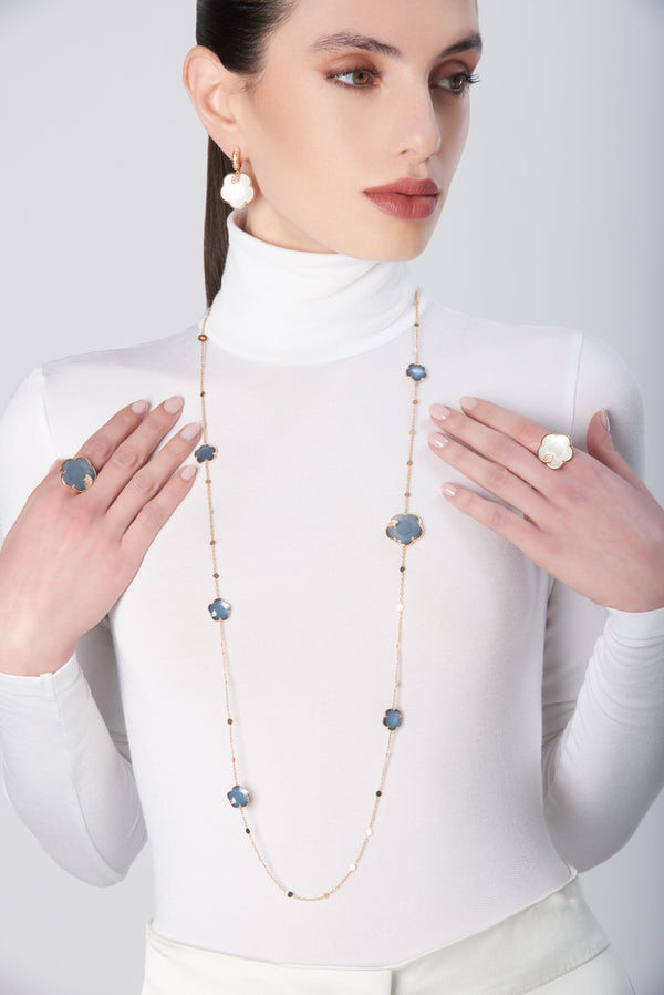 Earrings, rings and necklace in 18k Rose Gold with coloured gemstones and diamonds on model in white turtleneck