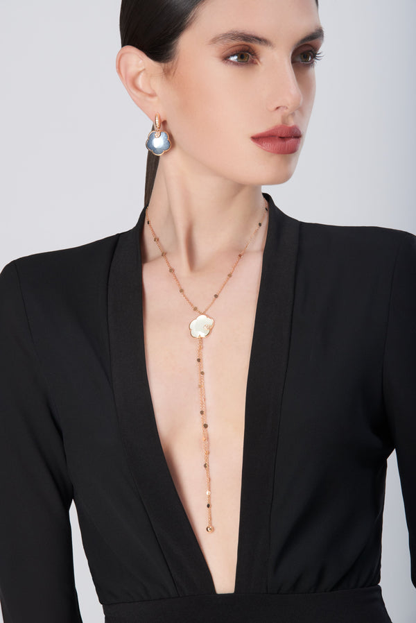 Necklace in 18k rose gold with pearl gem and diamonds and earrings in 18k rose gold with blue gemstones on model in black dress