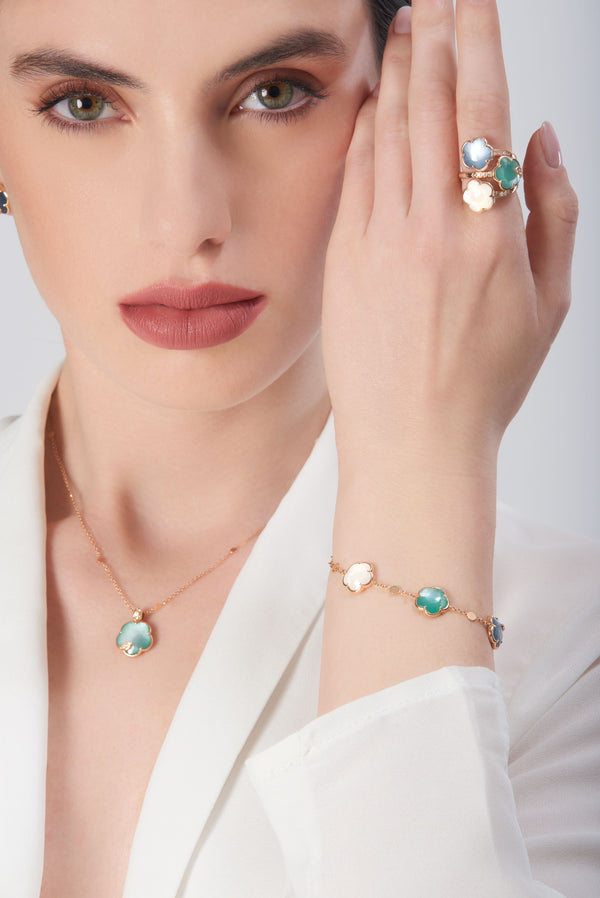 Necklace, bracelet, and ring in 18k rose gold with pearl gem, diamonds and colored stones on model in white blouse