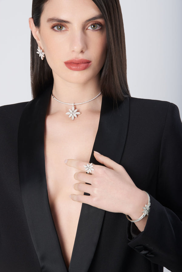 Necklace, earrings, ring, and bracelet in 18k white gold with diamonds on model in black jacket