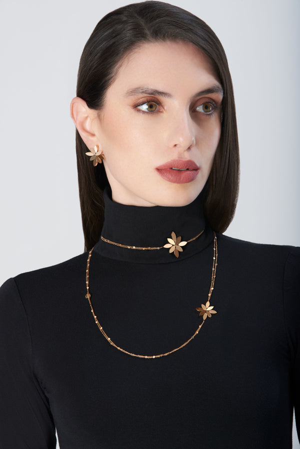 Sautoir in 18k Rose Gold. Earrings in 18k Rose Gold on model wearing black turtleneck