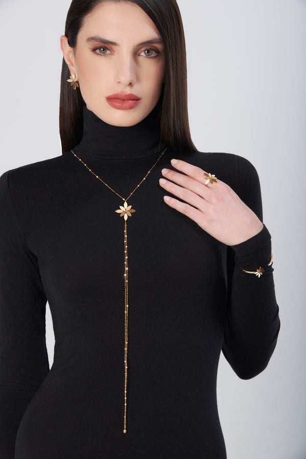 Sautoir in 18k Rose Gold. Earrings in 18k Rose Gold on model wearing black turtleneck