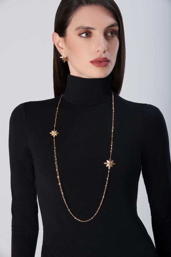 Sautoir in 18k Rose Gold. Earrings in 18k Rose Gold on model wearing black turtleneck