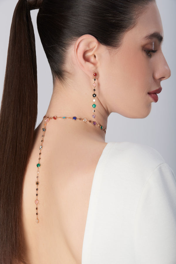 Necklace and earrings in 18k rose gold with colorful gemstones on model in white blouse