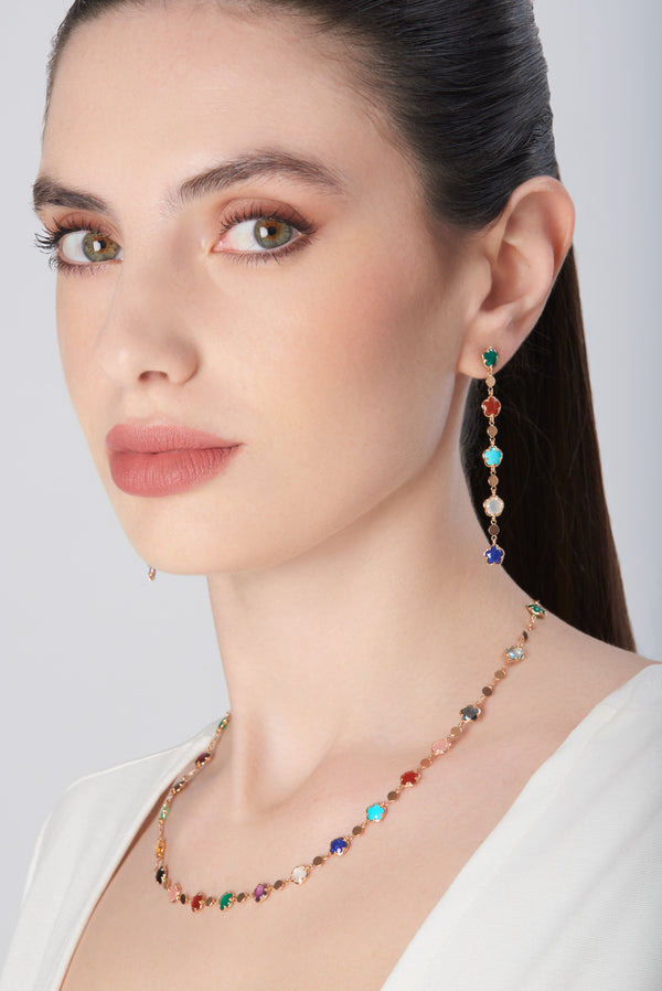 Necklace and earrings in 18k rose gold with colorful gemstones on model in white blouse