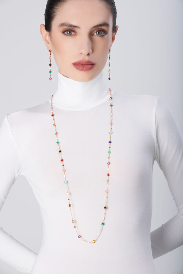 Sautoir in 18k rose gold with multicolored gemstones and diamonds worn with matching earrings and white turtleneck