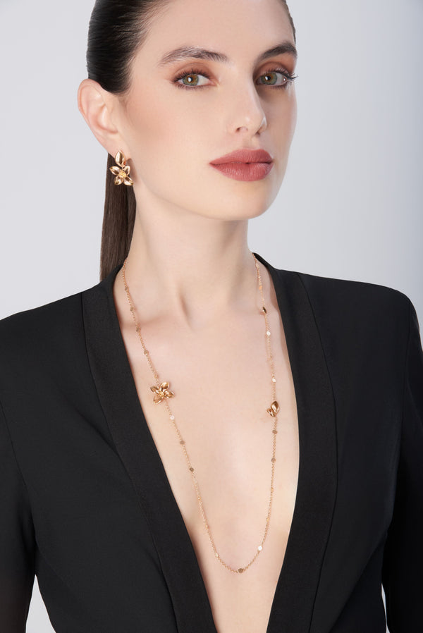 Sautoir necklace and earrings in 18k rose gold on model in black dress