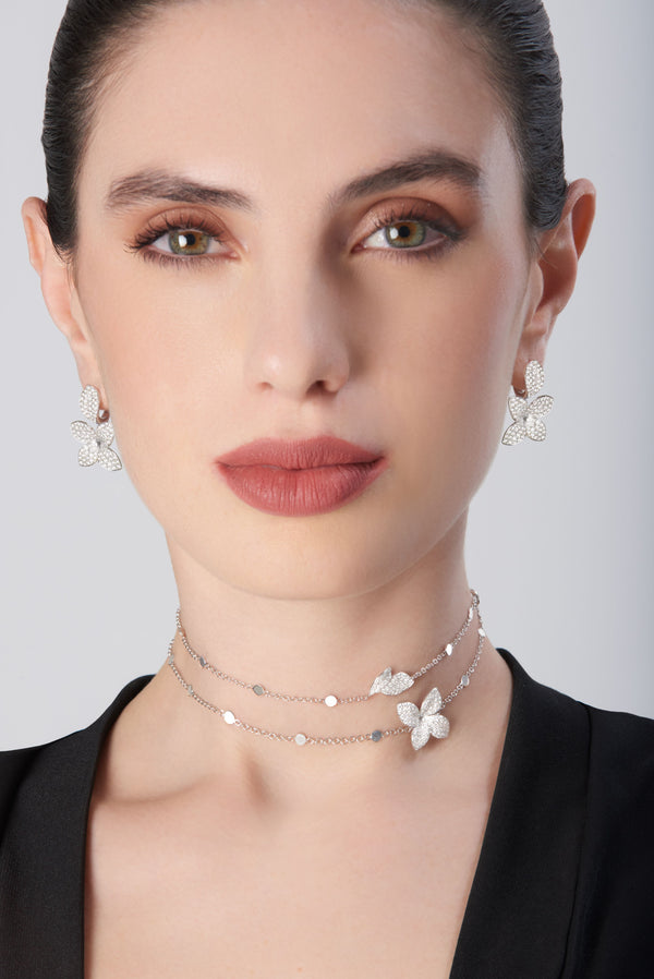 Necklace in 18k white gold with diamonds and matching earrings on model dressed in black