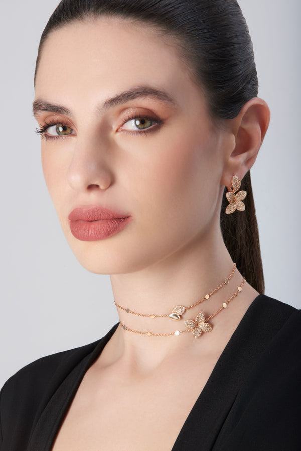 Necklace and earrings in 18k rose gold with diamonds, worn by model in black jacket