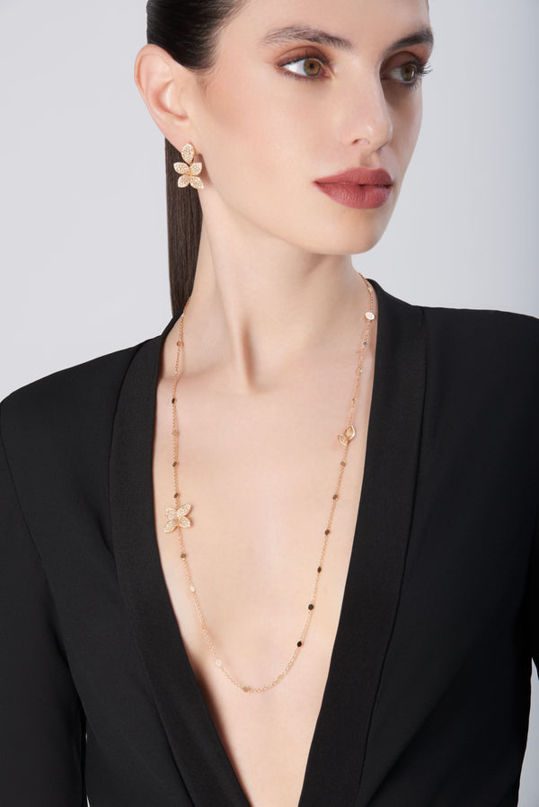 Necklace and earrings in 18k rose gold with diamonds, worn by model in black jacket