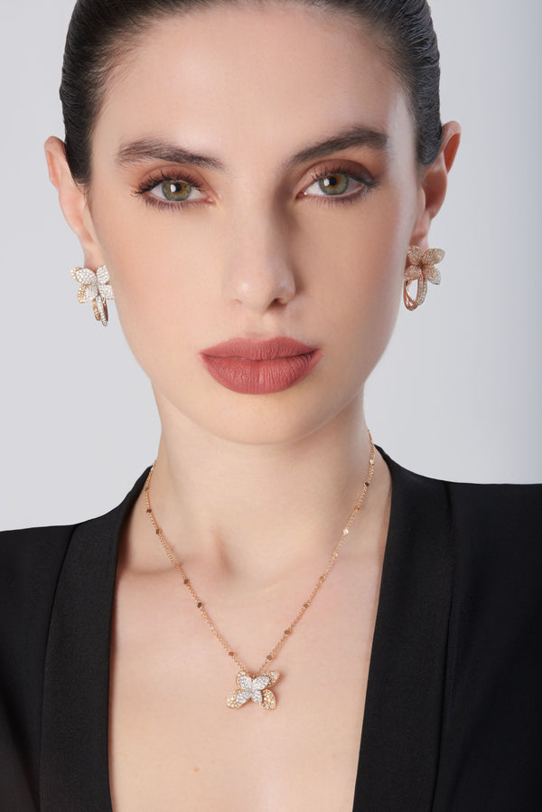 Necklace and earrings in 18k white and rose gold with diamonds worn by model in black attire