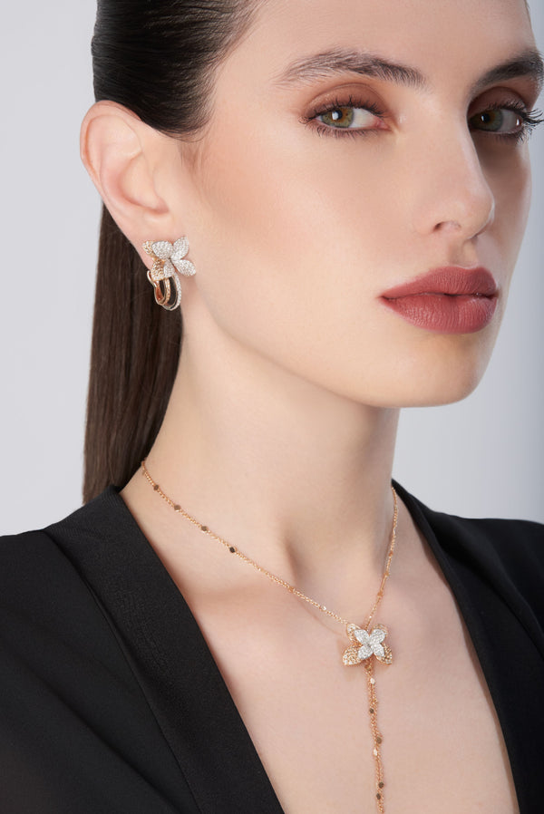 Earrings and pendant necklace in 18k rose gold with diamonds, worn with a black blouse
