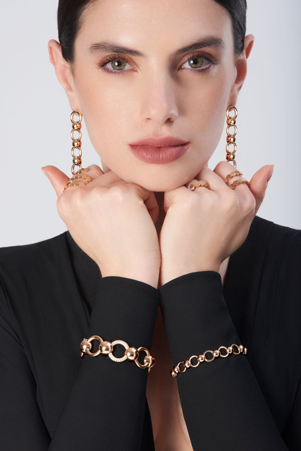 Jewelry set from the Luce collection in 18k rose gold with circular motifs on model wearing black long-sleeve outfit