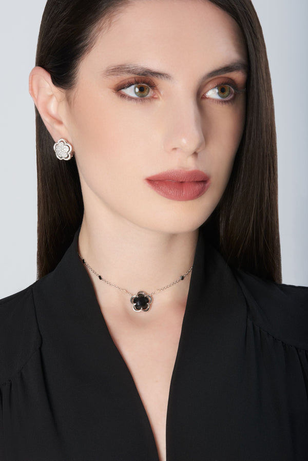 Necklace and earrings in 18k white gold with diamonds and onyx worn by a model in a black blouse