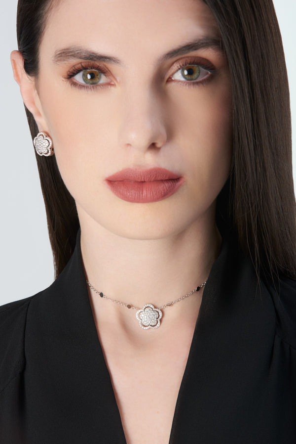Necklace and earrings in 18k white gold with diamonds and onyx worn by a model in a black blouse