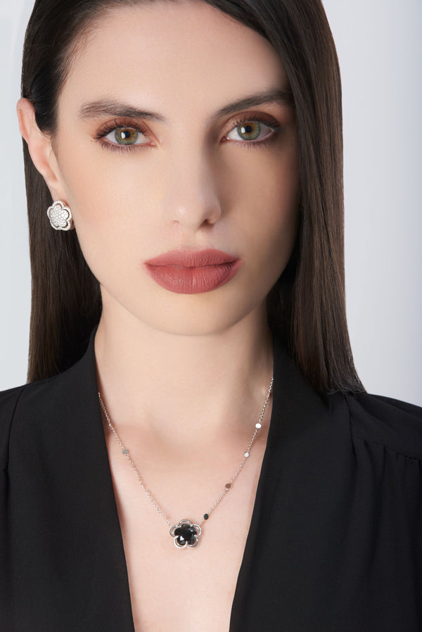 Necklace in 18k white gold with onyx and diamonds, paired with earrings on model in black blouse