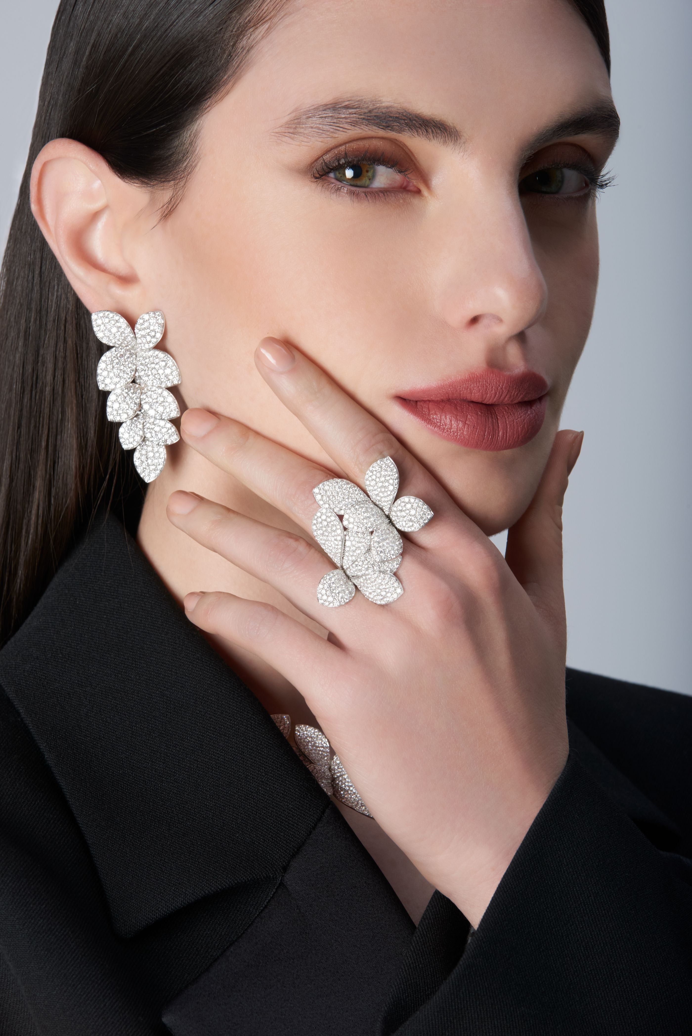Woman wearing a black jacket and Ring and earrings in 18k White Gold with White Diamonds.