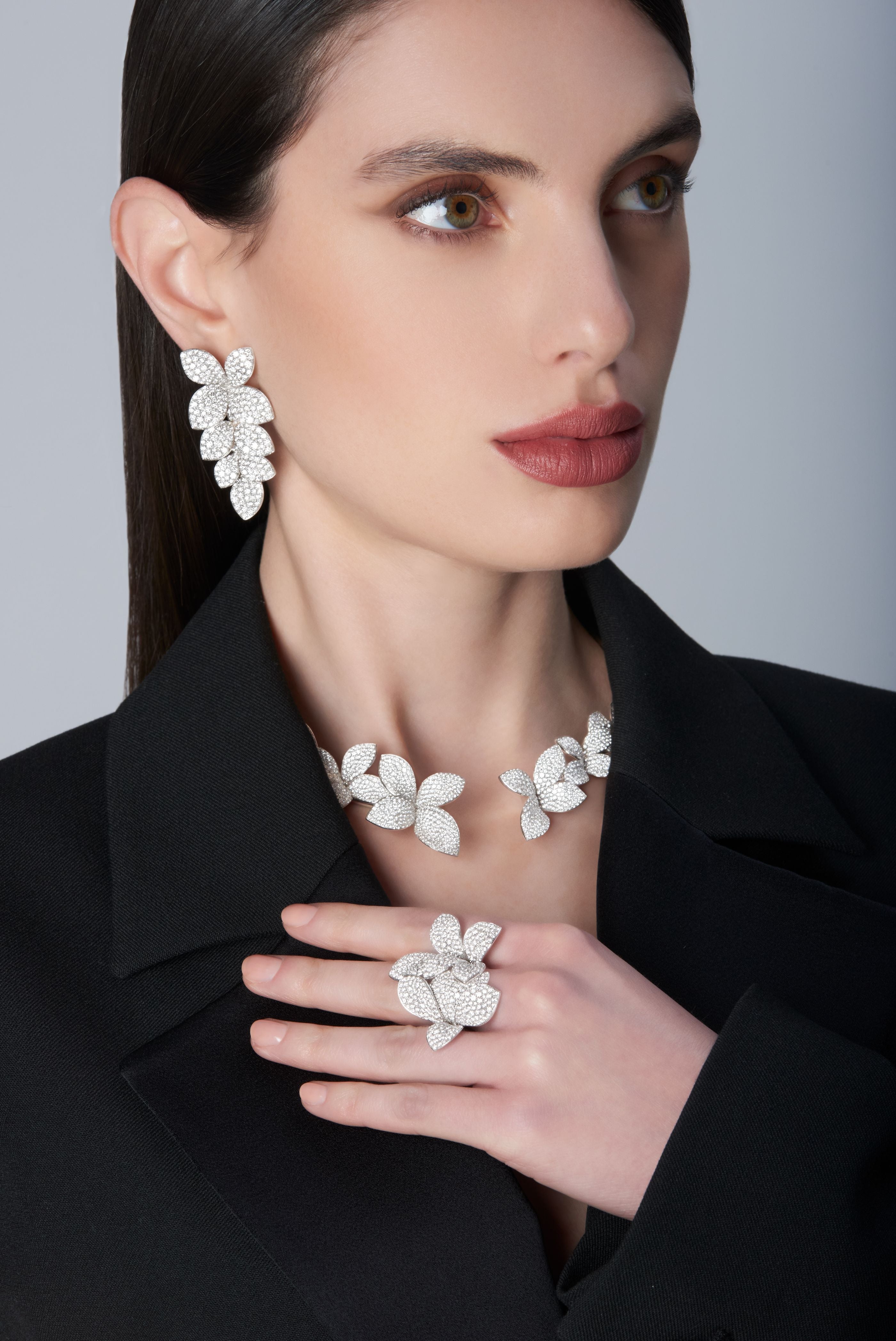Woman wearing a black jacket and Ring and earrings in 18k White Gold with White Diamonds.