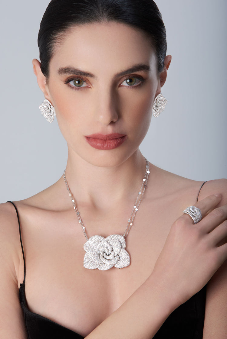 Women wearing a black top with a 18k white gold necklace, earrings and ring