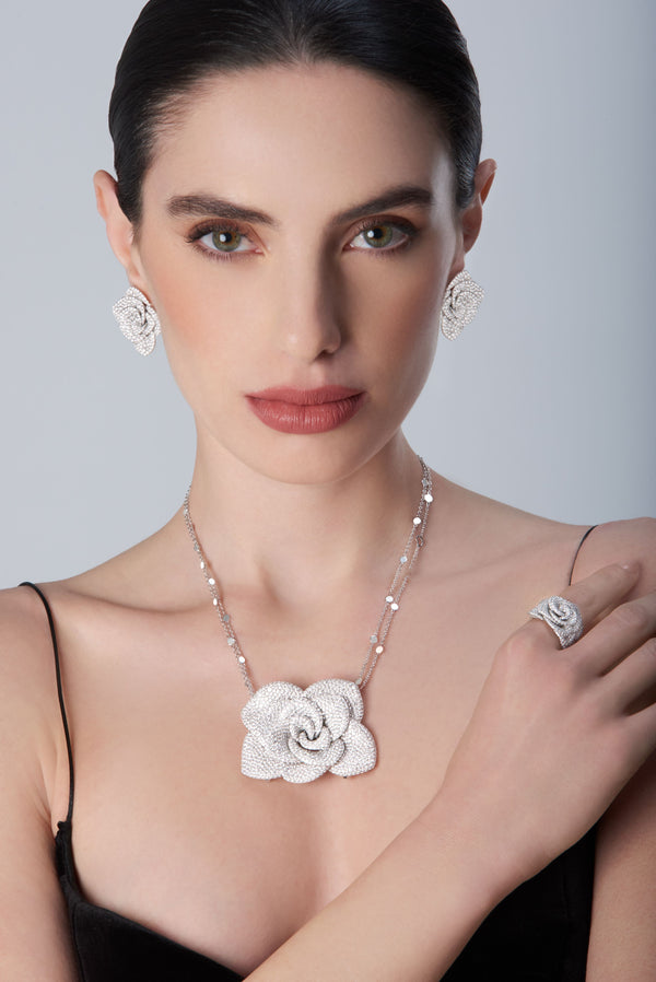 Women wearing a black top with a 18k white gold necklace, earrings and ring