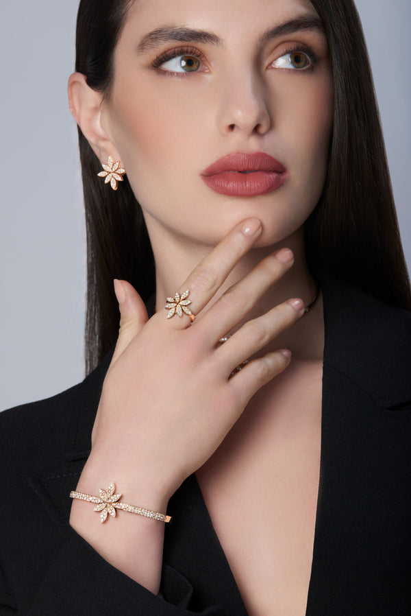 Woman wearing a black jacket and earrings, ring, and bracelet in 18k Rose Gold with diamonds