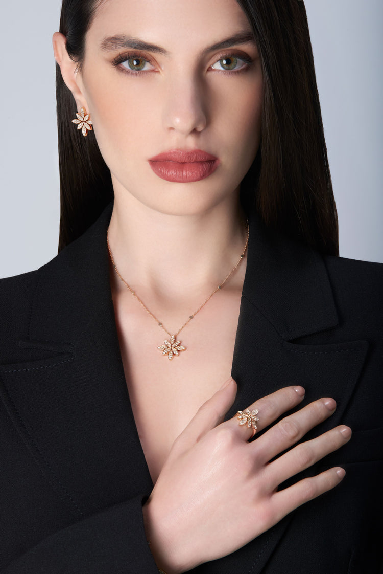 Woman wearing gold jewelry including a necklace, earrings, and ring in 18k Rose Gold with Diamonds