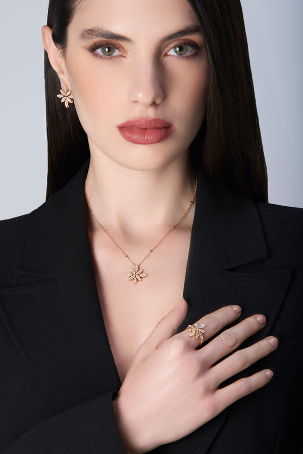 Woman wearing gold jewelry including a necklace, earrings, and ring in 18k Rose Gold with Diamonds