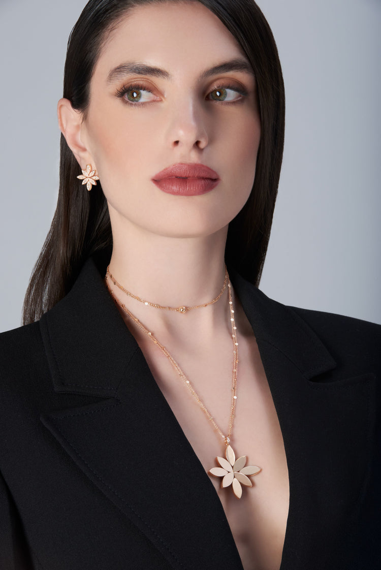 Model wearing a black jacket and earrings and necklace in 18k Rose Gold with Diamonds