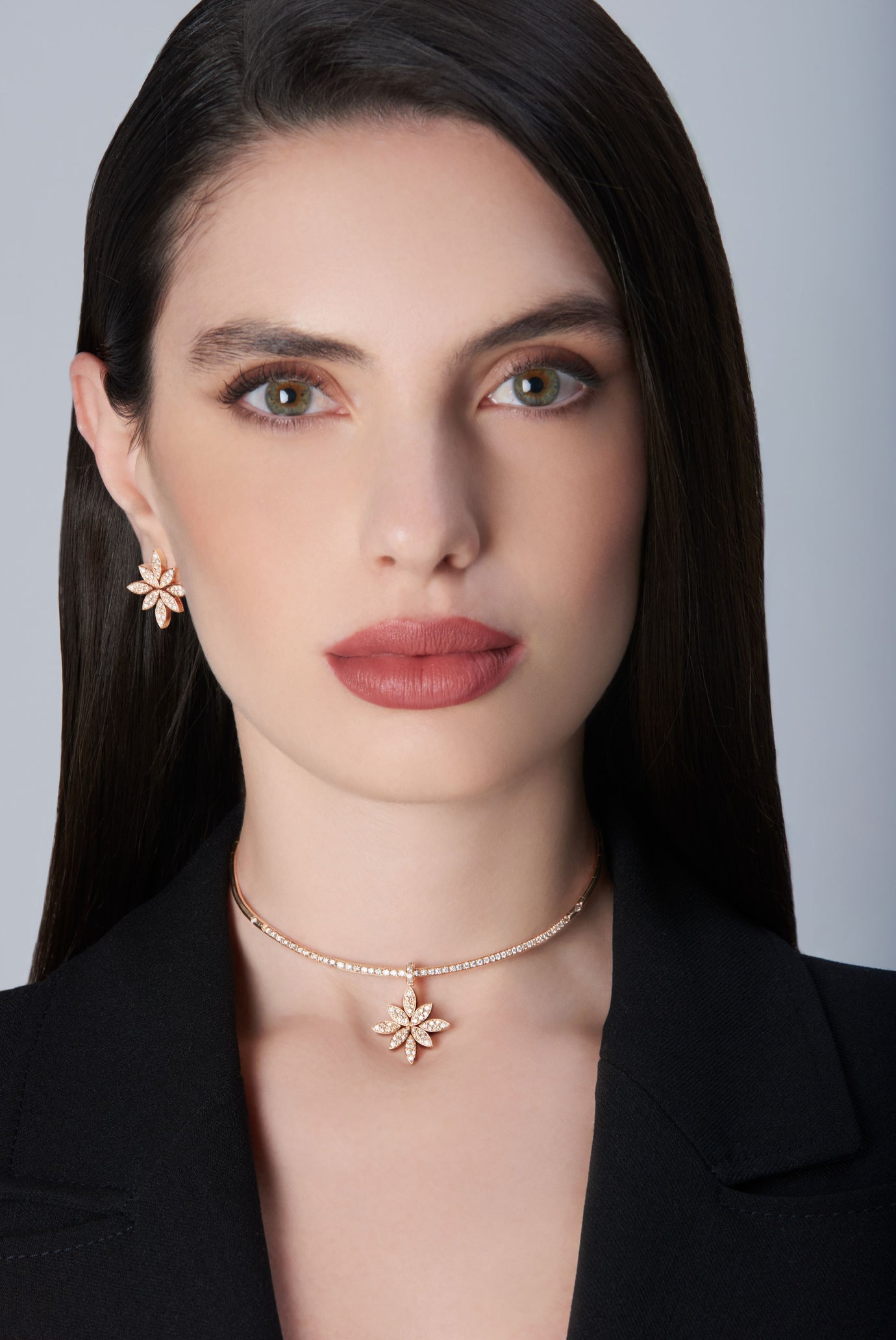 Model wearing a black jacket and earrings and choker in 18k Rose Gold with Diamonds