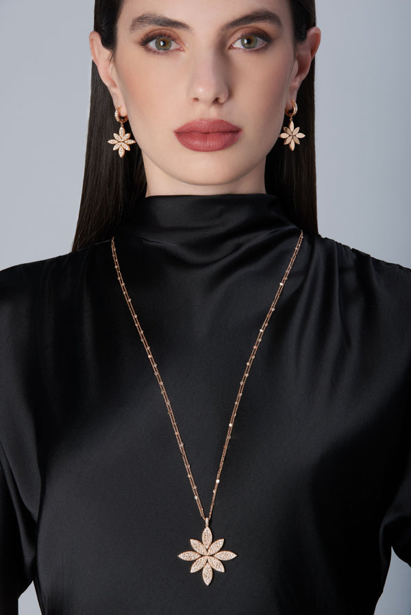 Model wearing a black dress and earrings and becklace in 18k Rose Gold with Diamonds