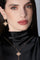Woman wearing a black outfit with gold earrings and necklace