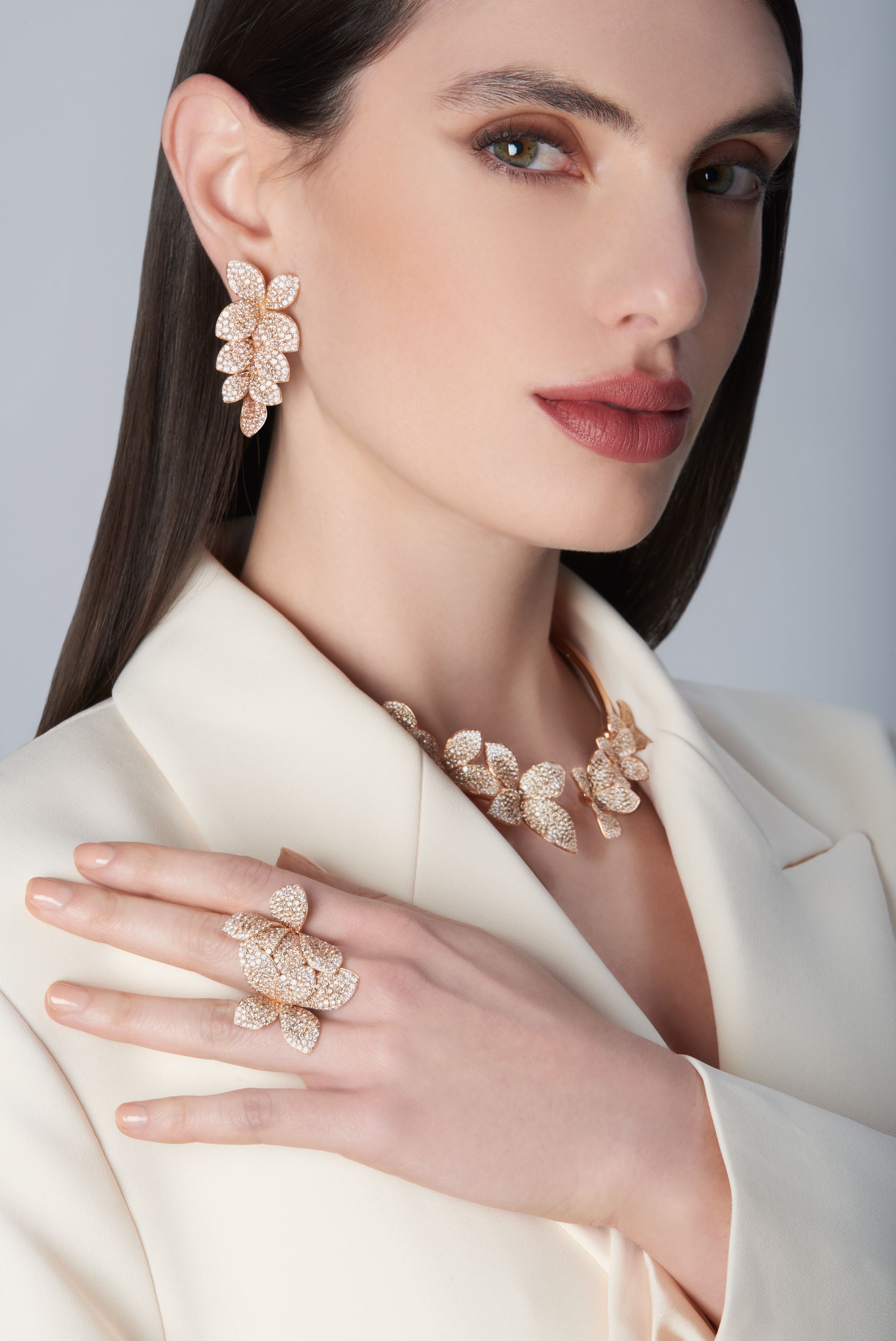 Model wearing a white jacket with Ring, choker and earrings in 18k Rose Gold with diamonds.