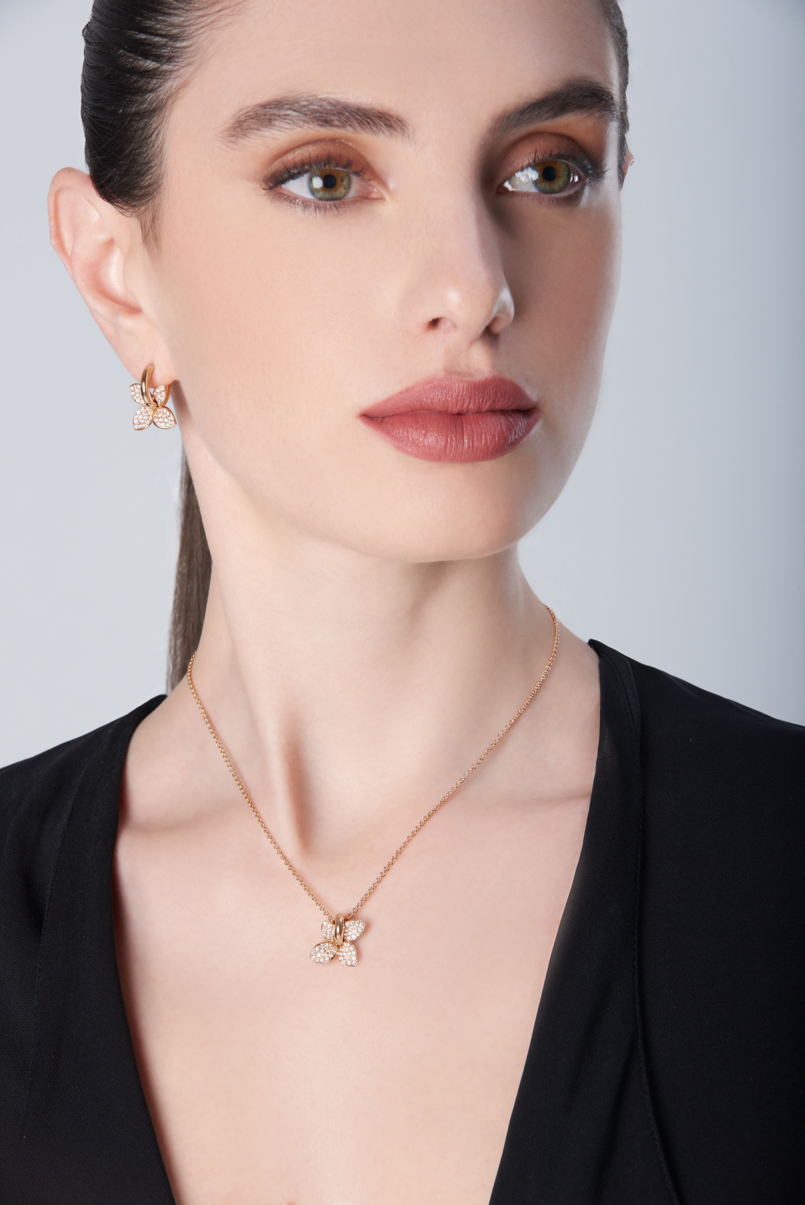 Earrings and necklace in 18k Rose Gold with Diamonds on model with V neck black shirt