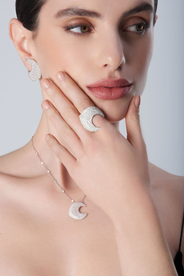 Woman wearing a black necklace, earrings, and ring in 18k white gold with diamonds