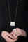 Woman wearing a black turtleneck with 18k white gold necklace and ring