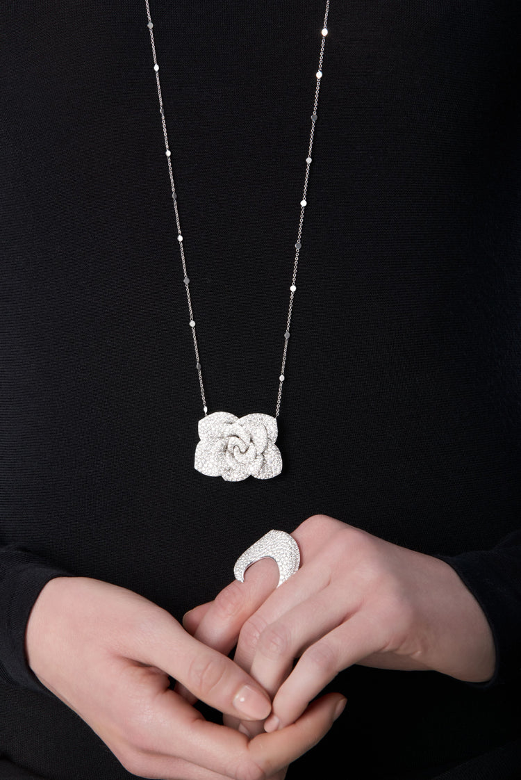 Woman wearing a black turtleneck with 18k white gold necklace and ring