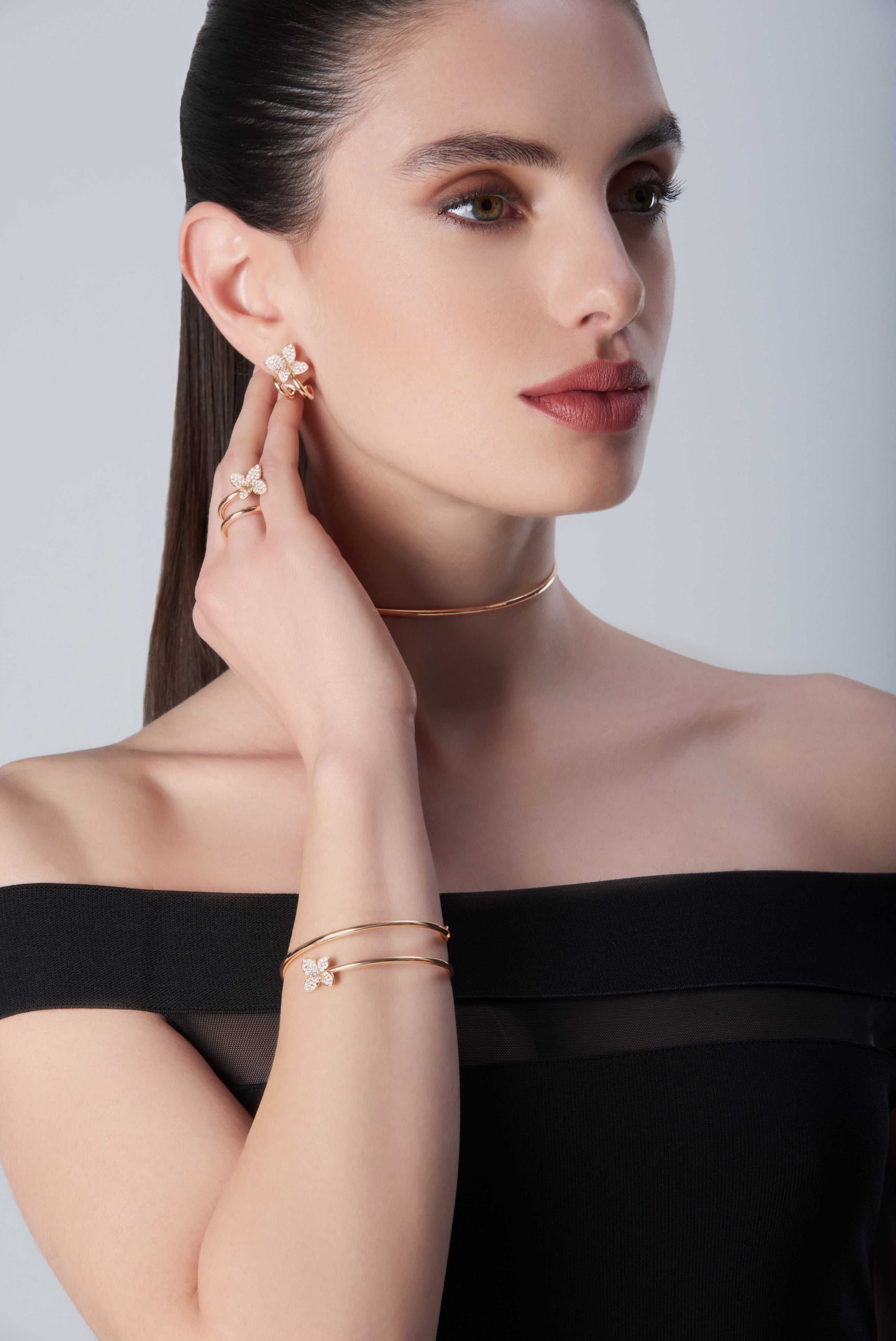 Composition of bracelet, earrings, ring and choker in 18k Rose Gold with Diamonds on model with black dress