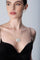 Woman wearing a black top with 18k white gold necklace and earrings