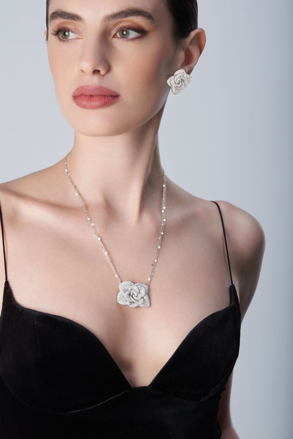 Woman wearing a black top with 18k white gold necklace and earrings