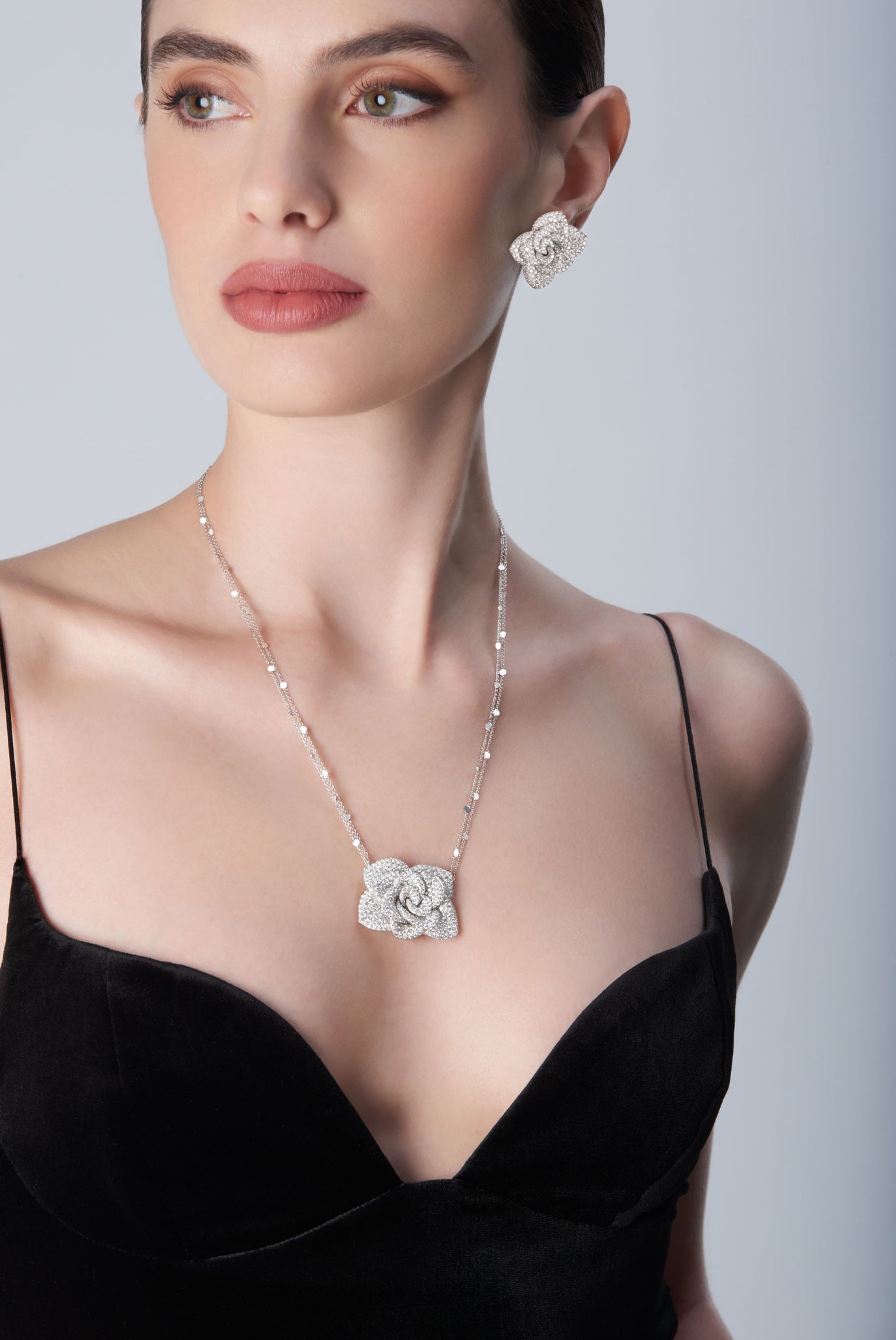 Woman wearing a black top with 18k white gold necklace and earrings