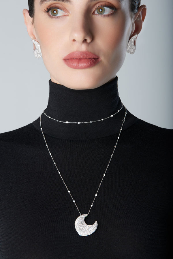 Woman wearing diamond earrings and necklace in 18k White Gold with white diamonds