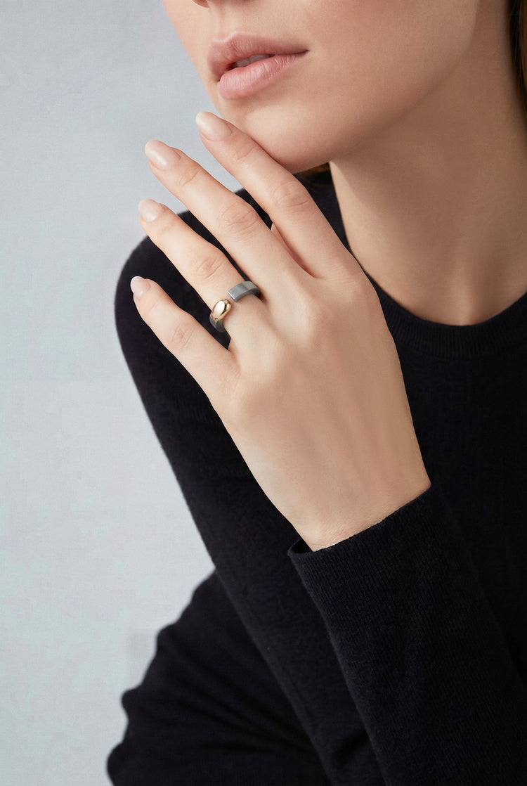 Model wearing a 18k rose gold and grey titanium and a black top with long sleeves